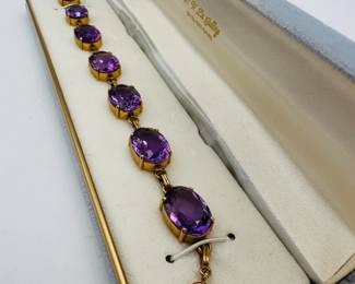 Another view of the vintage 14k yellow gold link bracelet featuring seven large oval-cut amethyst gemstones