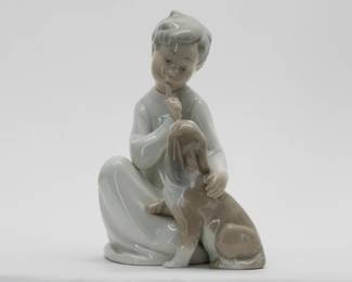 ​​A Lladro 'Boy with Dog' porcelain figurine No. 4522 GLOSS. Base marked with LLADRO Handmade in Spain. Measures 7-1/2 inches H. Head reattached.