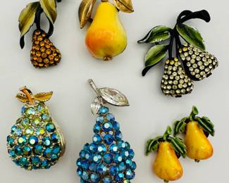 A selection of pear-form brooches and pins, four are vintage rhinestone brooches – one signed BSK another signed JJ — and an enamel and gold tone brooch, and a pair of pears as label pins