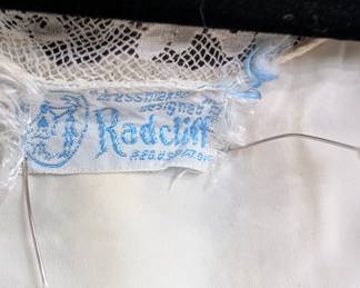 Closeup of the 1940s Radcliff ivory color dressing robe with lace detailing at neck, waist and cuffs; rayon
