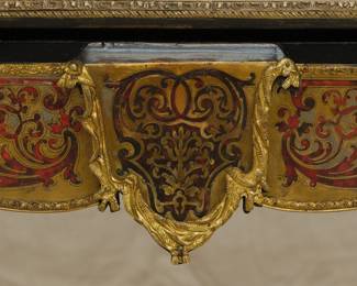 Closeup of the Napoleon III Boulle Inlay Bureau de Plat, 3rd quarter of the 19th Century. Crafted in the style of Louis XV with cabriole legs adorned with female allegorical figures, the red tortoiseshell top meticulously inlaid with brass depicting Diana the Huntress riding her chariot amidst scrolls and floral details. A large single drawer with a shield at center, and with a custom carved glass top.