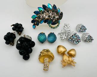 A vintage rhinestone acorns and oak leaves brooch with matching earrings, silver tone metal; a rare demi-parure of 1980s Lucite "Forbidden Fruit" black grapes with black rhinestones brooch and earrings set, a 1970s signed Napier gold tone mushroom brooch, a cute dimensional mushroom brooch, gold color over metal with clear rhinestones; a large Paisley shape rhinestone brooch, and a pair of strawberry shaped earrings, blue green glass, marked Austria.