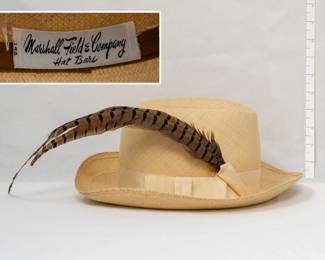 A vintage woven tan straw fedora hat with grosgrain ribbon band and a pheasant feather, inside label of Marshall Field & Company Hat Bars