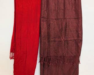 A vibrant red fringed scarf and a deep russet color brocade patterned fringed scarf