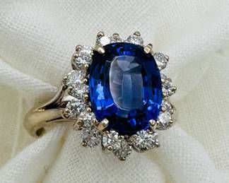 An 18kt gold ring set with an astounding deep blue tanzanite central stone surrounded two galleried levels of accent diamonds, size 7-1/4