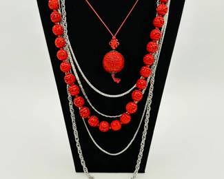 Dramatic Chinese carved cinnabar bead necklaces and a selection of silver tone chain necklaces 