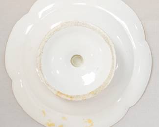 Closeup of underside of the antique porcelain compote dish or cake stand with hand-painted floral design in the center with a pink border and extensive gilt details