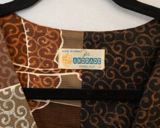 Closeup of a vintage 1970s Hawaiian brown and and gold sleeveless dress, inside label made in Hawaii for Andrade Honolulu
