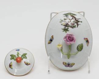 Two pieces of Hungarian Herend porcelain in the Rothschild Bird pattern: One oval lid with rosebud finial, 5" wide by 7" long, and one round lid with strawberry finial, 3" wide.