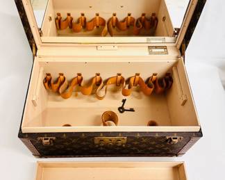 Another view of the 1980s vintage Louis Vuitton monogram Boite Bouteilles train case, a hard-sided trunk case crafted of Louis Vuitton Monogram coated canvas with a vachetta leather top handle, reinforced brass corner plates, S lock and two latches. The top opens to a beige leather interior with a full mirror set in the lid, vachetta leather belts for bottles, and a removable tray insert. Comes with a dust bag, name tag, and keys. Certificate of authenticity from Entropy.