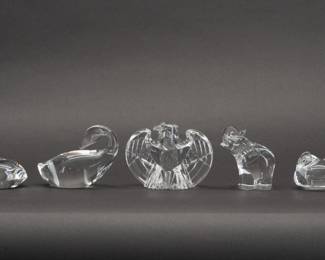 A selection of five Steuben Glass figurines rendered in sparkling colorless leaded glass and comprised of: Preening Goose (shape No. 8344) designed by Lloyd Atkins, Heart to Heart hand cooler (shape No. 8626) designed by Eric Hilton, an Eagle (shape 8496) designed by Lloyd Atkins, a Hen hand cooler, and an Elephant Hand Cooler (shape No. 5529) designed by Lloyd Atkins. All engraved with “Steuben' on the base.