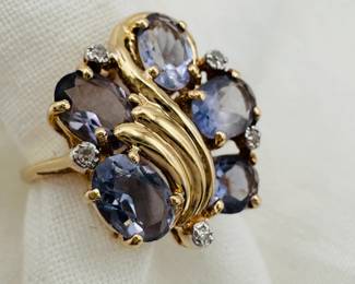 A 14k yellow gold ring set with 5 faceted oval gemstones and small accent diamonds, size 7-1/4