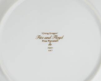 Closeup of the reverse side of the three Fitz and Floyd "Ching Dragon" porcelain plates crafted in Japan featuring a black and gold imperial dragon design