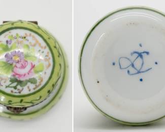 A vintage hand-painted Limoges porcelain trinket box, round form, with a brass hinge and a floral design on the lid encircled by two shades of green enamel