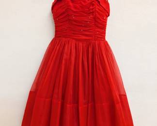 A vintage 1950s red chiffon cocktail dress with spaghetti straps and a tea-length skirt, the fitted and ruched bodice decorated with rhinestones.