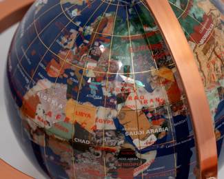 Closeup of a handcrafted gemstone stone world globe with lapis ocean, on a copper-plated stand