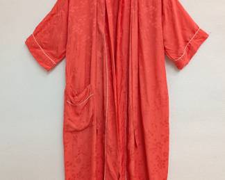 A vintage coral or reddish-orange color robe made in Japan, with floral pattern embroidery and white piping along the collar, cuffs, and pockets