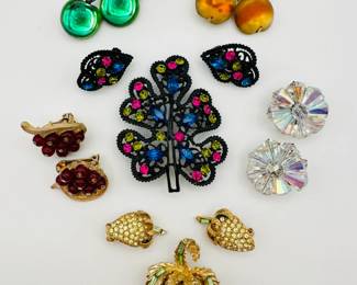 A signed Loran glass and rhinestone cherry brooch, a signed Pell demi-parure featuring rhinestone strawberry brooch and earrings; a signed Austria cherry shaped brooch, a demi-parure in black enamel and rhinestones (brooch and earrings), and two pair of rhinestone and beaded clip earrings