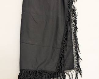 A black shawl or scarf with deeply fringed borders
