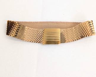 A vintage gold-tone metal fish scale stretch belt with a rectangular buckle