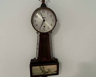 M46 - $25. Sessions Clock. Eight Day Lever Time. Mahogany Finish Case. Measures 7.5" wide x 23.5" tall. 