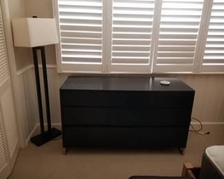 Black dresser; contemporary floor lamp
