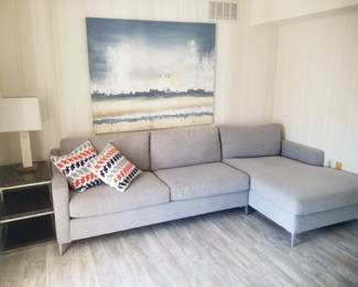 Gray sectional sofa; end table; table lamp
