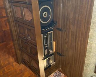 vintage Zenith console stereo with a record player, radio, and an 8-track player. It is a mid-level model from the late 1960s or early 1970s
