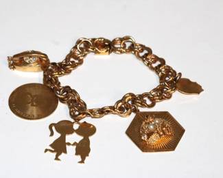 14kt Yellow Gold Charm Bracelet (43.9 grams total) with 5 14kt Gold Charms and one has a basket of what appears to be pearls and diamonds