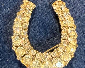 A vintage horseshoe brooch with clear rhinestones