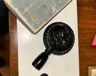 Trio-ette  triple powder rogue and mirror compact. The lipstick fits into the end of the handle in both sides open up, so the lady can freshen up. Comes with the original box.