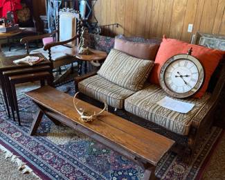 Carved wood sofa, wood bench, antlers, clock, nesting tables, carpet