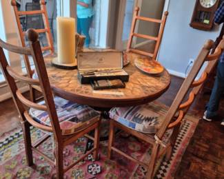 Round tile topped dining table with four chairs.