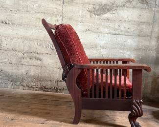 This lot features a stunning antique Morris chair with an adjustable back, removable cushions, and a spindle design on the sides with carved paw feet. This chair measures, 39” H x 31” W x 30.5” D.
