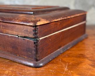 This lot features what appears to be a Victorian writing slope or lap desk. Locks and comes with the original skeleton key, with beautiful patina throughout. Please note, there is no "slope" and has a flat box surface inside. This stunning piece measures, 5” H x 14.5” W x 17.5” D.
