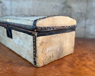 This lot features an antique trunk, most likely an immigrant trunk circa 1890s. The trunk is made of wood and animal hide with a lined paper interior. This trunk measures, 8” H x 21” W x 10.5” D.
