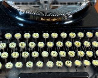 This lot features an antique Remington portable typewriter with a four-bank QWERTY keyboard, a folding type bar mechanism that raises the type bars for typing and lowers them for storage, making the machine compact, and housed in a carrying case. These typewriters were among the earliest and most successful portable models, first introduced in 1920.
