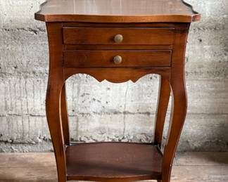 This lot features a Louis XV-style carved wooden nightstand with two drawers and cabriole legs in very good condition. This nightstand measures, 27.5” H x 17.5” W x 12.5” D.
