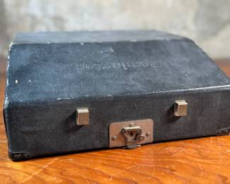 This lot features an antique Remington portable typewriter with a four-bank QWERTY keyboard, a folding type bar mechanism that raises the type bars for typing and lowers them for storage, making the machine compact, and housed in a carrying case. These typewriters were among the earliest and most successful portable models, first introduced in 1920.
