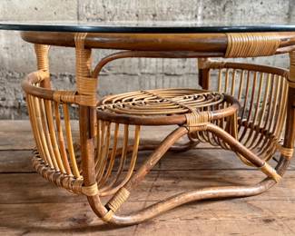 This lot features a vintage bamboo and rattan coffee table with a glass top, circa 1970s. In good overall condition and measures, 15” H x 30” W x 30” D.
