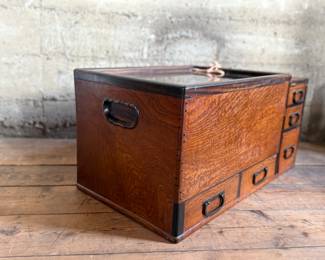 This lot features a Japanese hibachi cabinet with five (5) drawers, and a removable glass lid above the copper lined well. This cabinet measures, 14” H x 28” W x 15” D.
