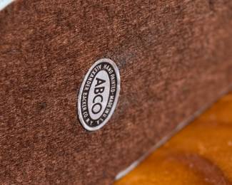 This lot features a sculpture of a jockey on a horse jumping over a fence, manufactured by ABCO, otherwise known as the Alexander Backer Company. In good overall condition with minor wear shown in photos, original ABCO sticker underneath, and measures, 9” H x 11” W x 3.5” D.
