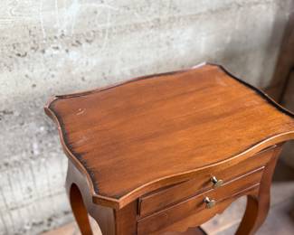 This lot features a Louis XV-style carved wooden nightstand with two drawers and cabriole legs in very good condition. This nightstand measures, 27.5” H x 17.5” W x 12.5” D.
