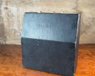 This lot features an antique Remington portable typewriter with a four-bank QWERTY keyboard, a folding type bar mechanism that raises the type bars for typing and lowers them for storage, making the machine compact, and housed in a carrying case. These typewriters were among the earliest and most successful portable models, first introduced in 1920.
