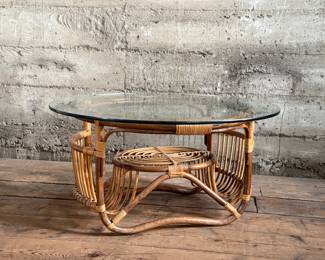 This lot features a vintage bamboo and rattan coffee table with a glass top, circa 1970s. In good overall condition and measures, 15” H x 30” W x 30” D.
