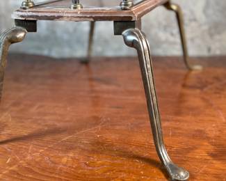 This lot features an Art Nouveau brass and wood magazine rack circa 1930s that measures, 18.5” H x 20.5” W x 12.5” D.
