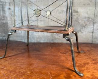 This lot features an Art Nouveau brass and wood magazine rack circa 1930s that measures, 18.5” H x 20.5” W x 12.5” D.
