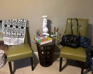 Coach purses, olive green chairs , decor and coffee table books 