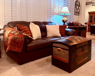 Brown leather couch and vintage chest