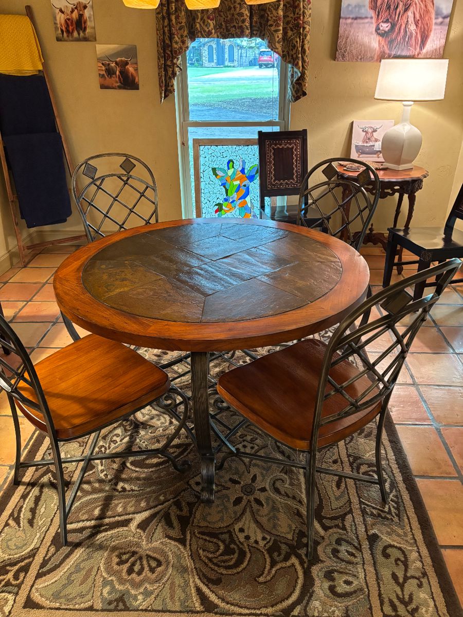 Beautiful slate top dining table, four  heavy matching dining chairs, decorative rug, antique side table, ladder, lamp, and pictures